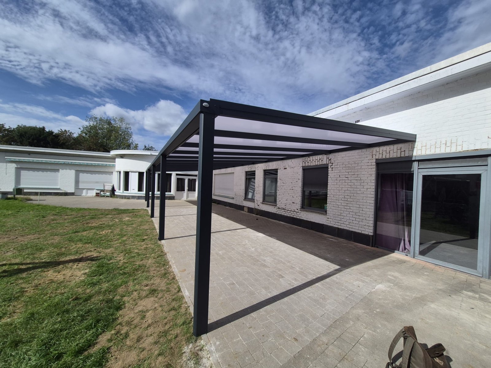 Polycarbonaat overkapping langs een schoolgevel – realisatie Coverit