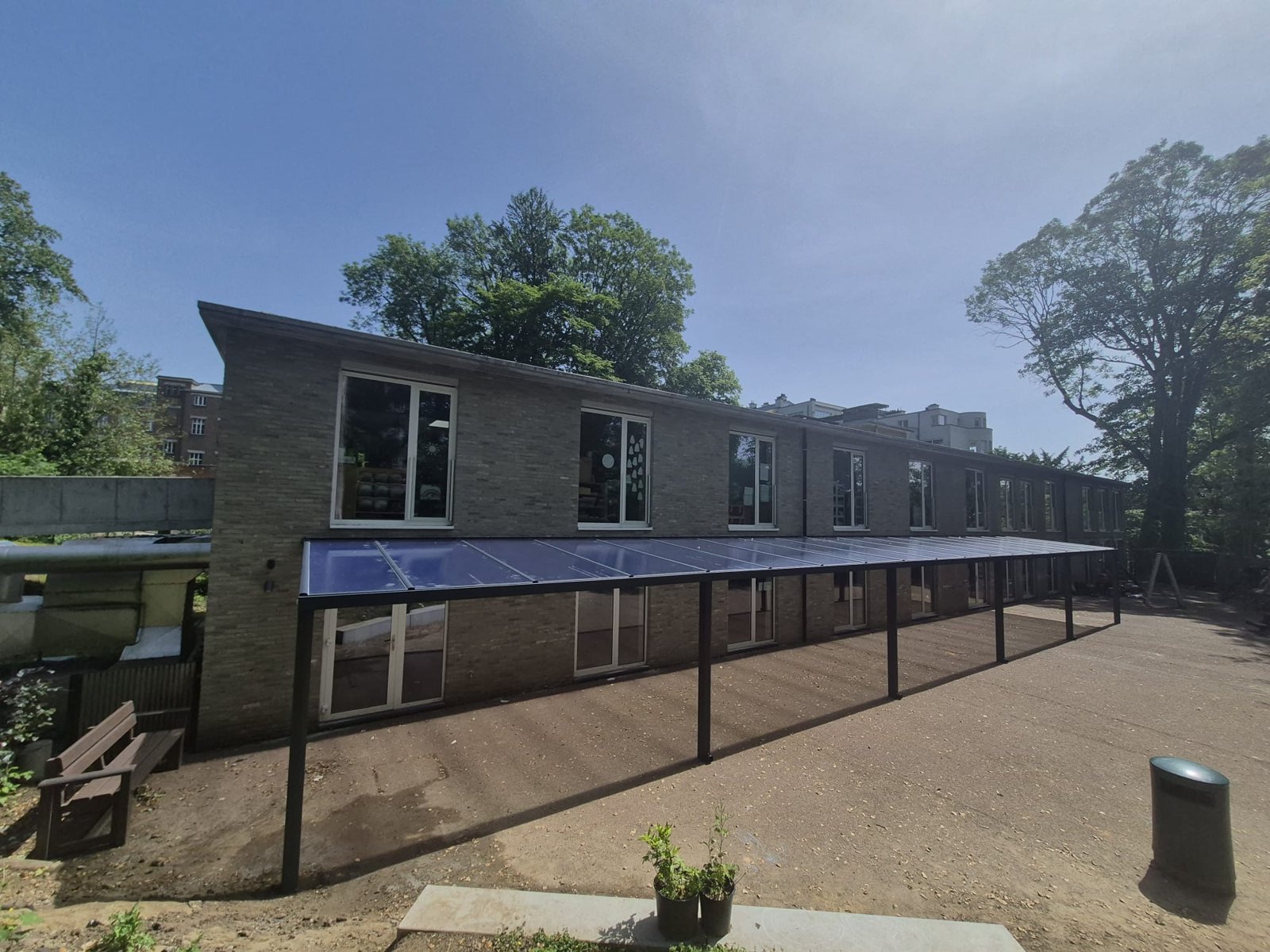 Polycarbonaat overkapping langs een schoolgevel – realisatie Coverit