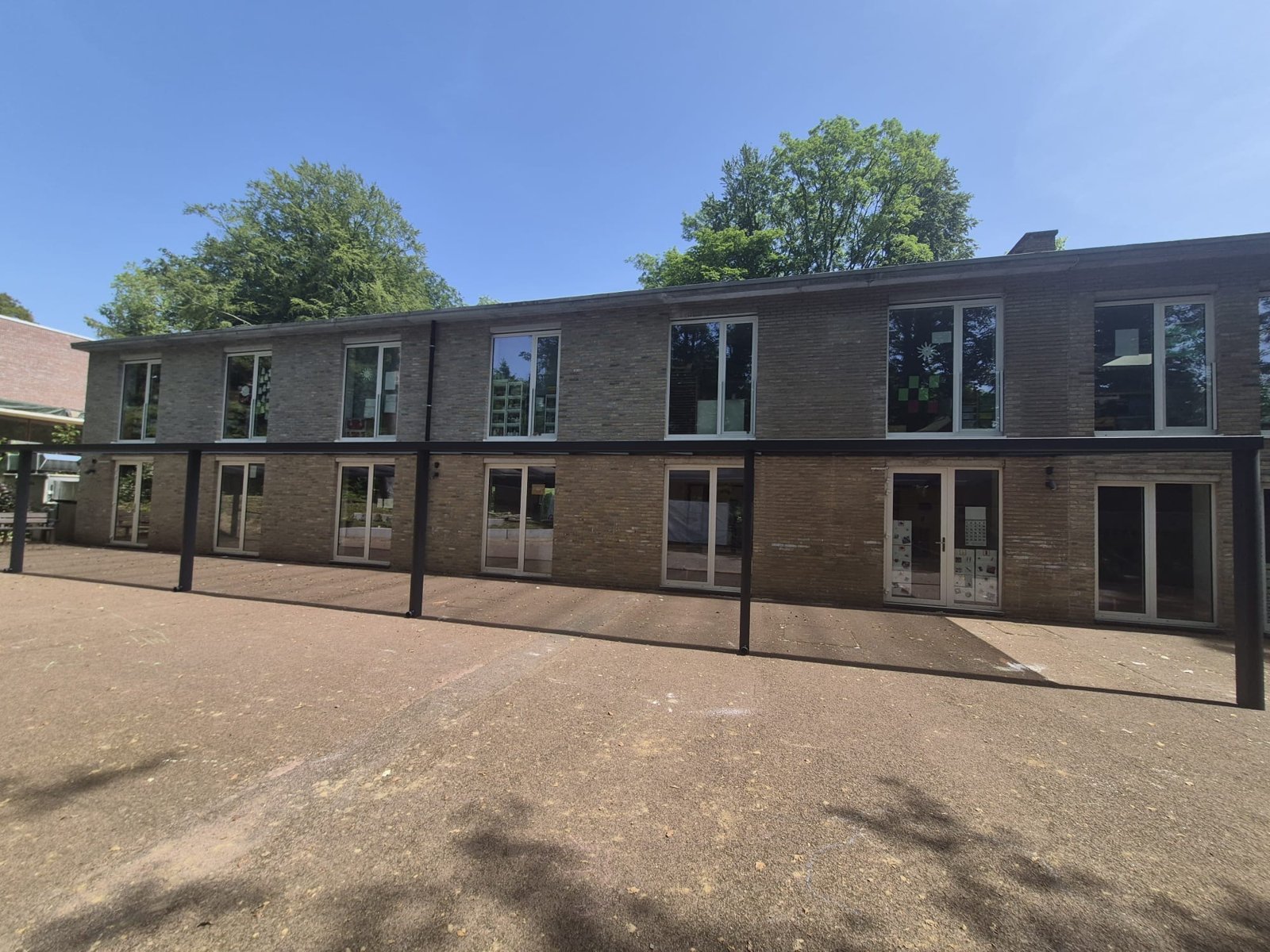 Polycarbonaat overkapping langs een schoolgevel – realisatie Coverit